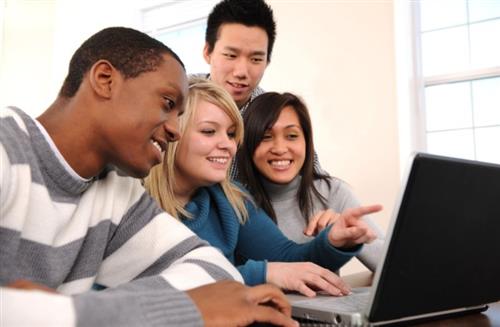 Students gathered around a laptop Students gathered around a laptop